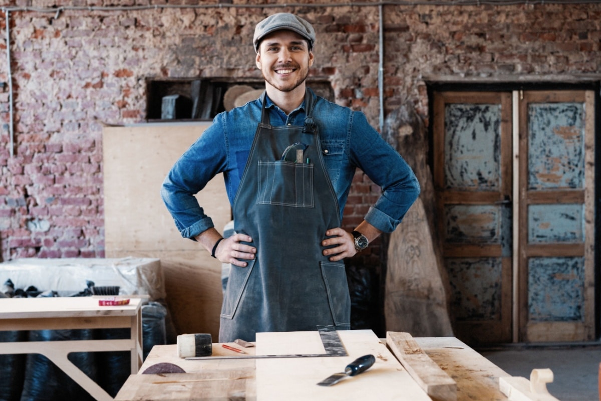Junger Geselle arbeitet an Holz in der Werkstatt