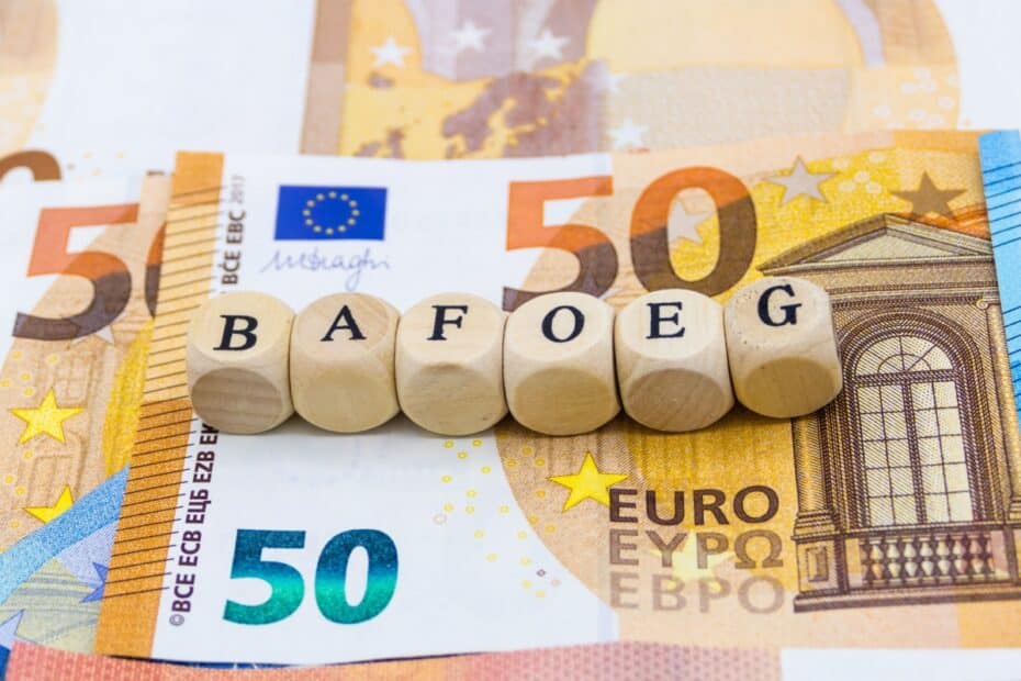 "BAföG" in Holzbuchstaben auf Geldscheinen, Symbol für Förderung