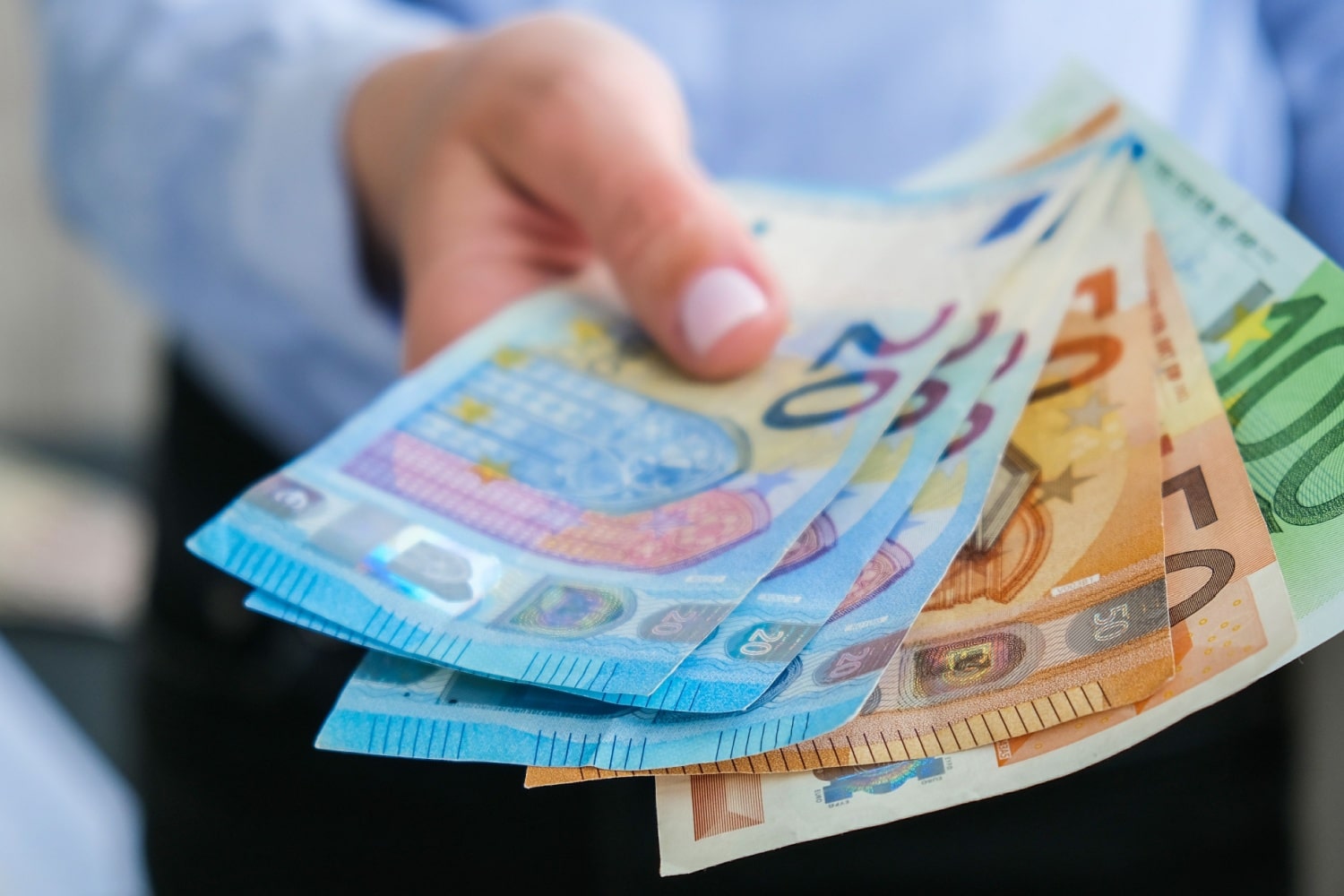 Hand hält Geldscheine hin, symbolisch für Förderung